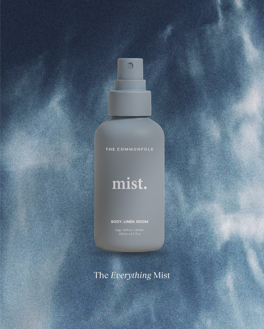 Gray mist spray bottle labeled 'The Everything Mist' on a blue misty background