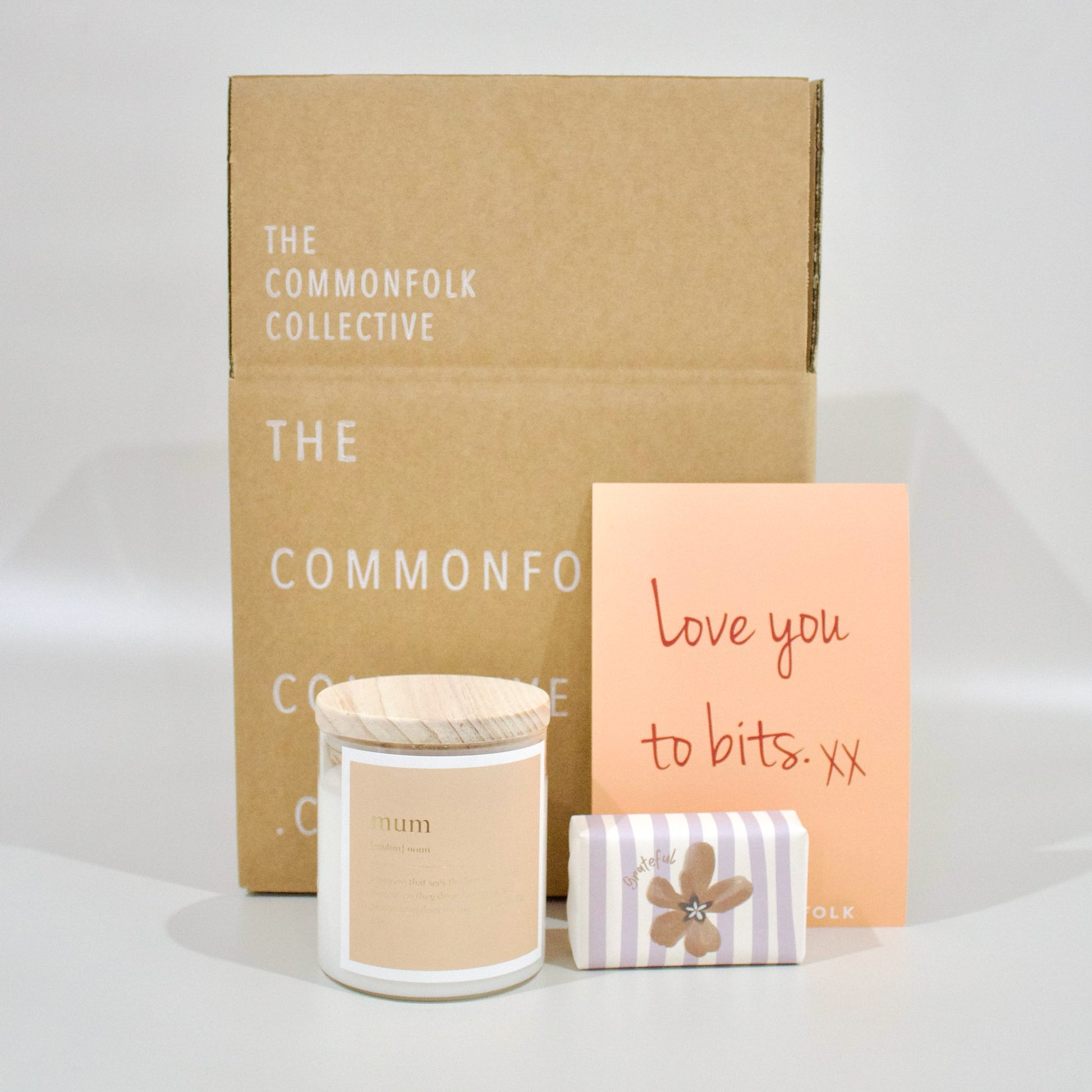 A gift box bundle featuring a clear jar candle, bar soap, and a gift card.