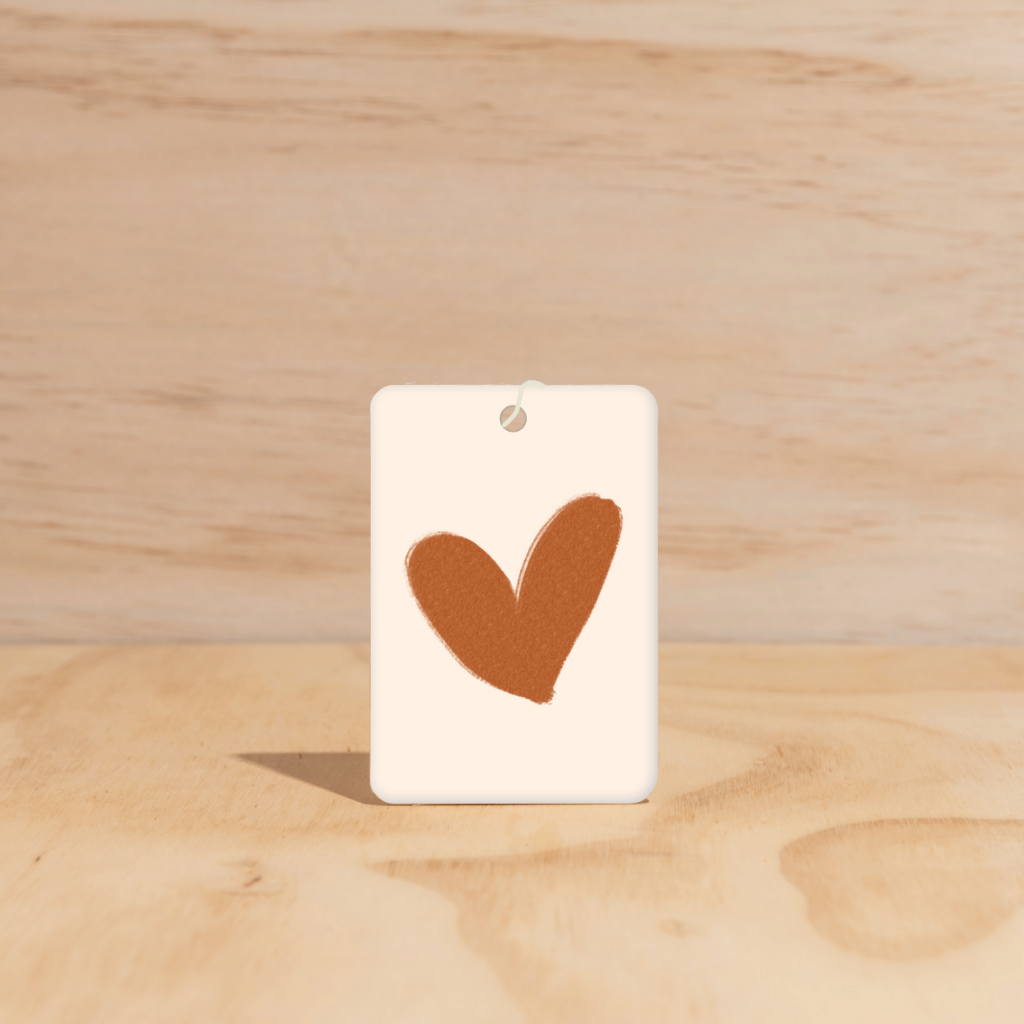 The Commonfolk air freshener, with a heart shape cut out in the center on a white background.