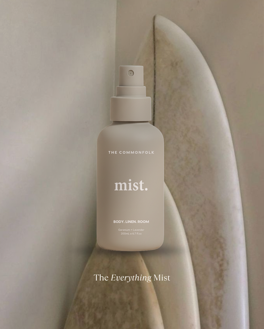 White spray bottle labeled 'mist' on a textured beige surface