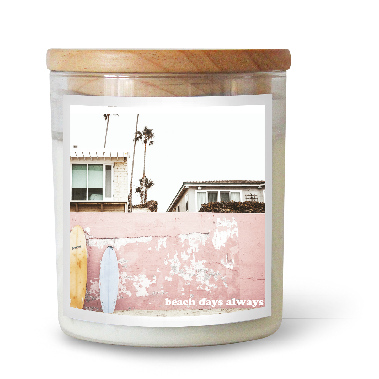 The Commonfolk scented white candle with a wooden lid features an image of a beach scene with palm trees and the text "beach days always" on the label.