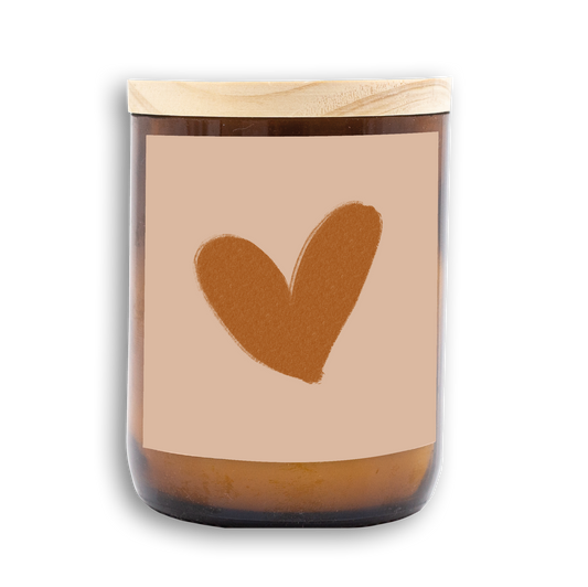 The Commonfolk scented candle features a heart-shaped design on the label, a wooden lid, and an amber-colored jar.