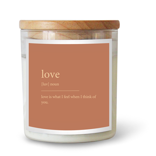 The Commonfolk scented white candle with a wooden lid and a label that reads 'love' and has a definition below it.