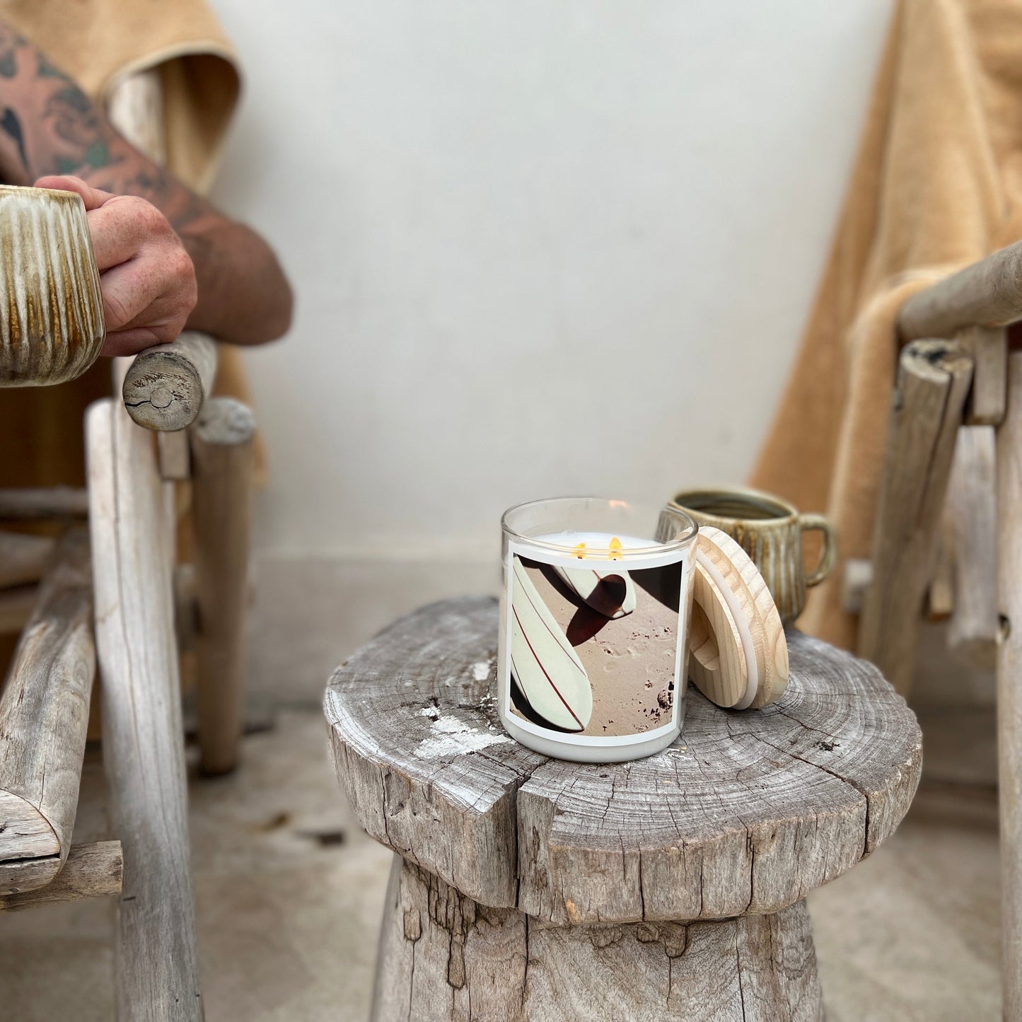 A wooden stand with a scented candle, along with a cup of tea.