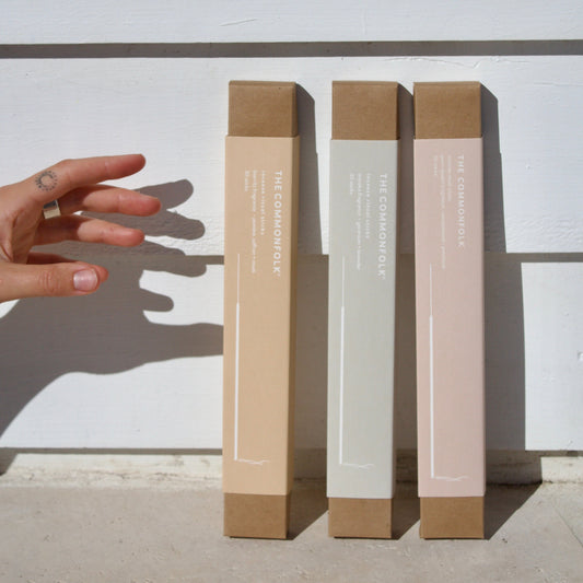 Three cylindrical boxes with different color finishes on a white background