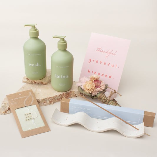 The Commonfolk gift box collection includes a hand and body wash, hand and body lotion, air freshener, incense ritual sticks with a holder, a gift card, and a dried flowers smudge stick.