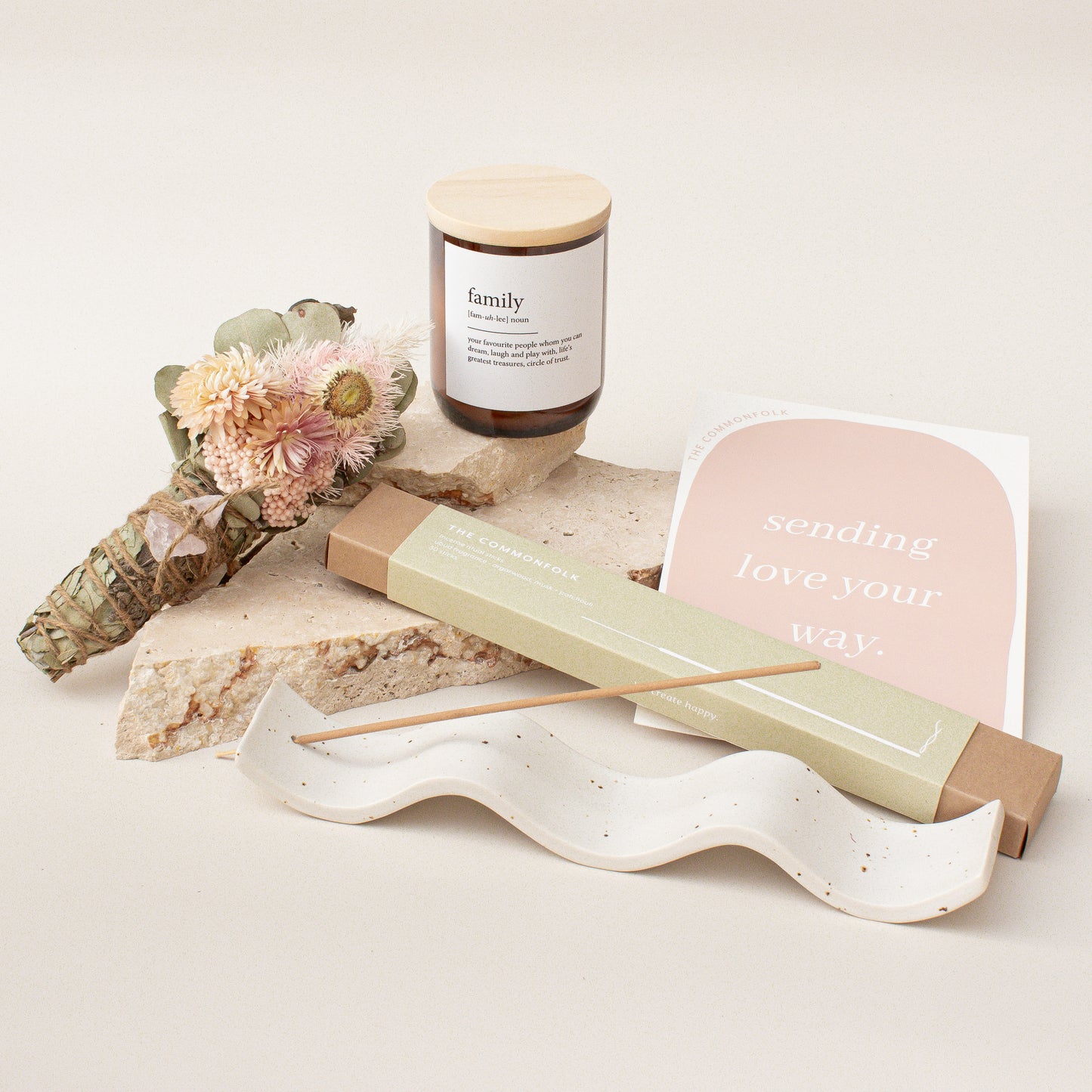 The Commonfolk gift box set includes a candle, incense sticks, an incense holder, a gift card, and dried flowers on a light-colored background.