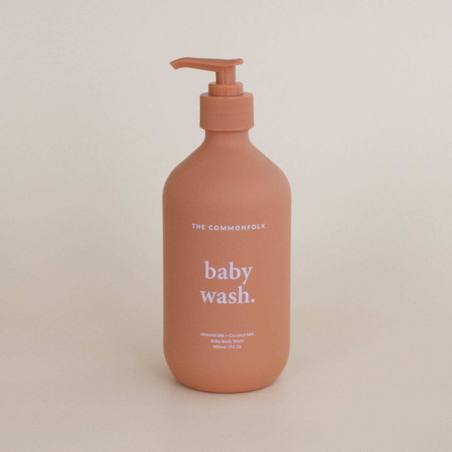 The Commonfolk matte finish 500ml bottle of baby wash with a pump dispenser, in a terra color, with 'baby wash.' displayed on the label.