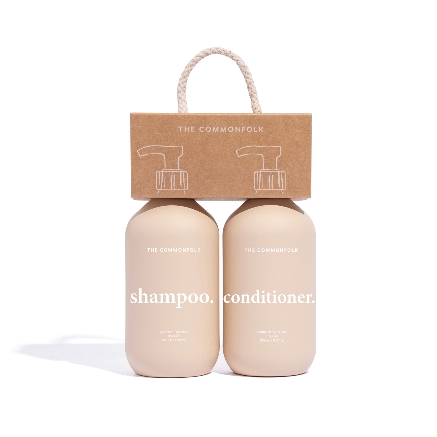 The Commonfolk shampoo and conditioner nude matte finish, 500ml bottles, one labeled as shampoo and the other as conditioner, packaged in a recycled Kraft carry caddy with a rope handle.
