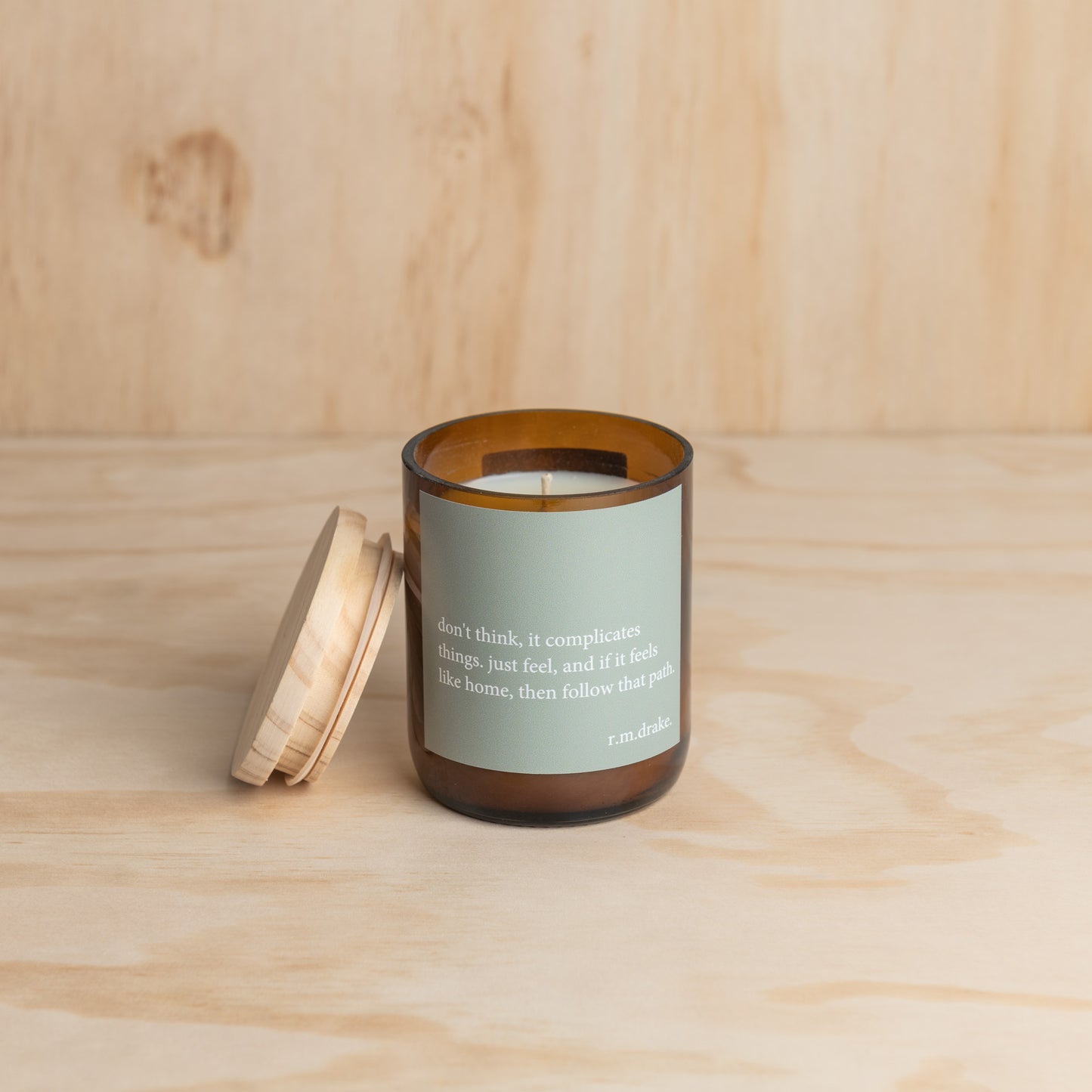 Candle in a glass jar with a wooden lid, showcasing a simple and elegant design.