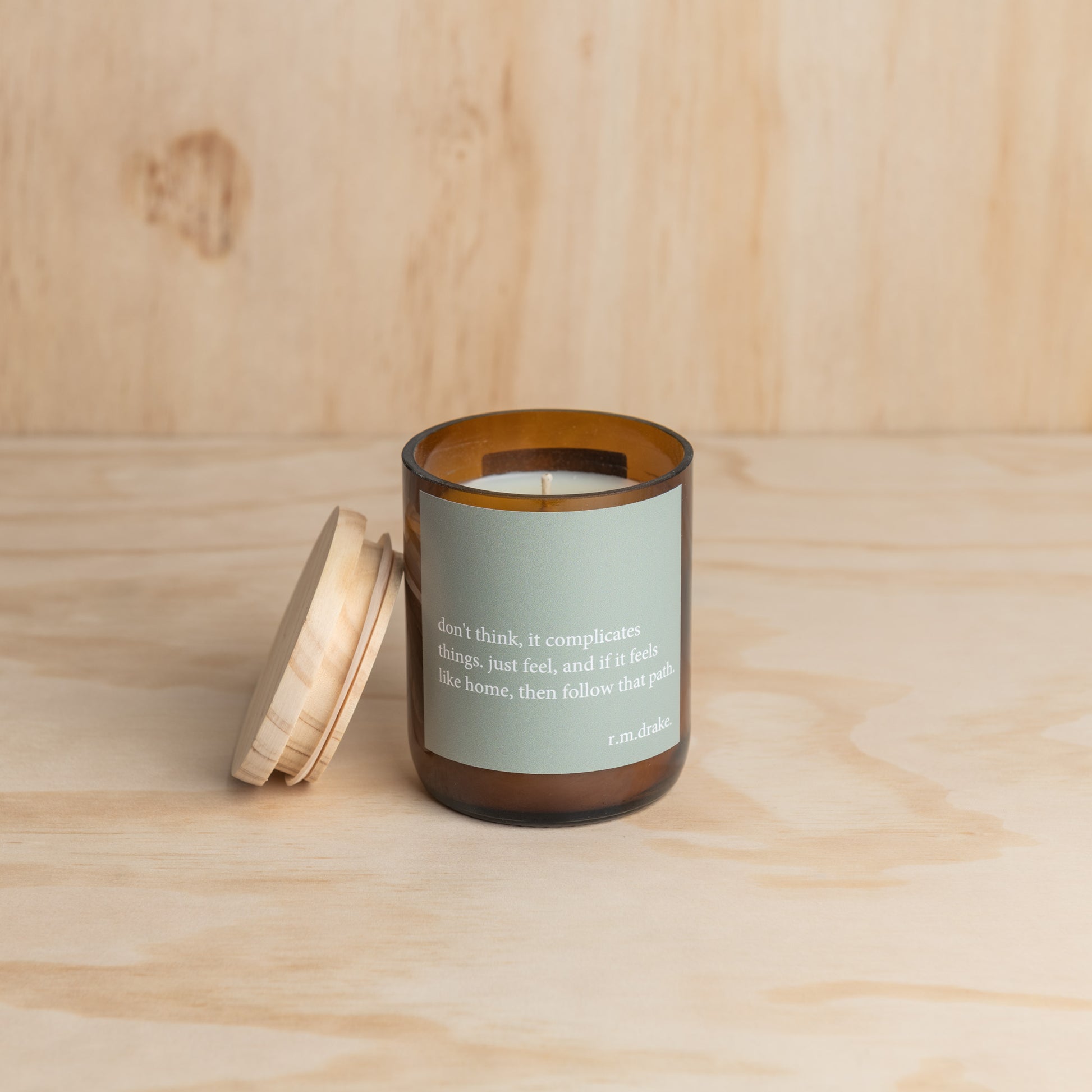 Candle in a glass jar with a wooden lid, showcasing a simple and elegant design.