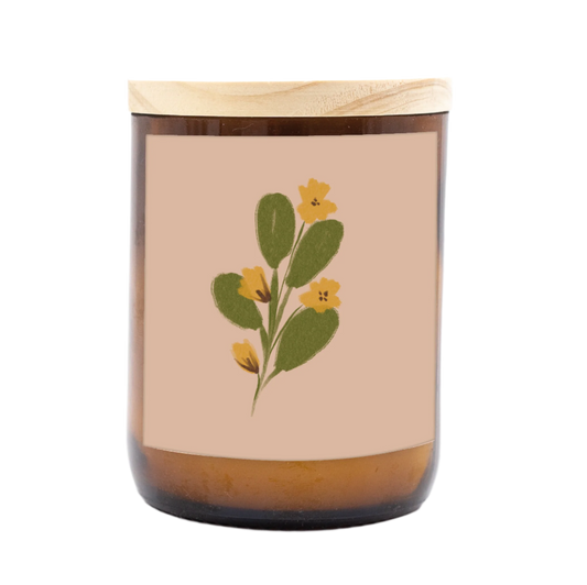 The Commonfolk scented mid-sized candle has a floral design on its container, featuring yellow flowers and green leaves, with a wooden lid.