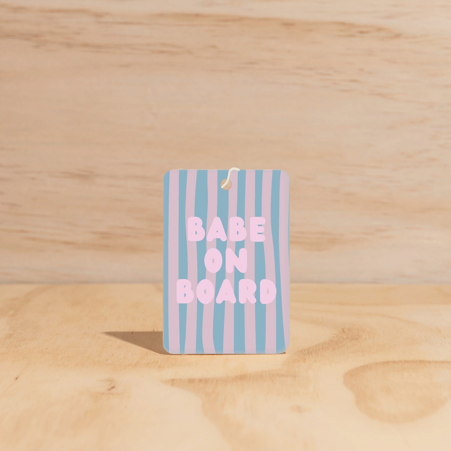 The Commonfolk air freshener features a striped blue and purple design with the text 'BABE ON BOARD' printed in large letters.