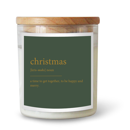 The Commonfolk scented white candle with a wooden lid and a green label that reads 'christmas' and its definition.