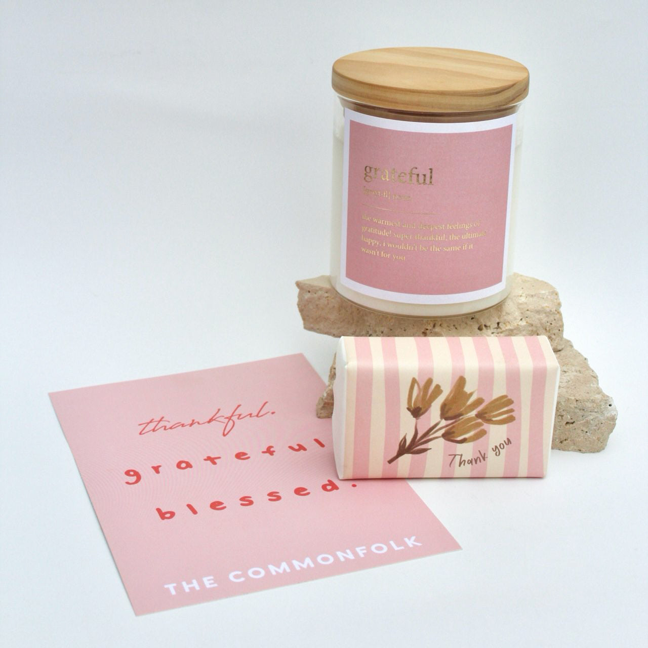 Clear jar candle labeled 'grateful', bar soap, and a gift card for a gift box bundle.