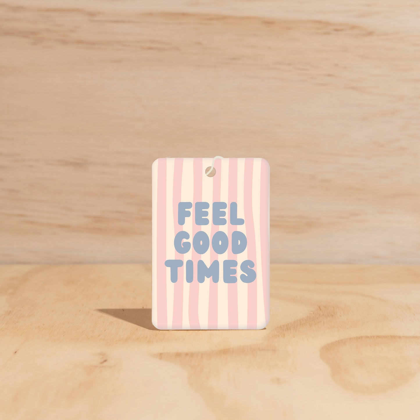 The Commonfolk air freshener features a striped pattern with the text 'FEEL GOOD TIMES' printed in the center.
