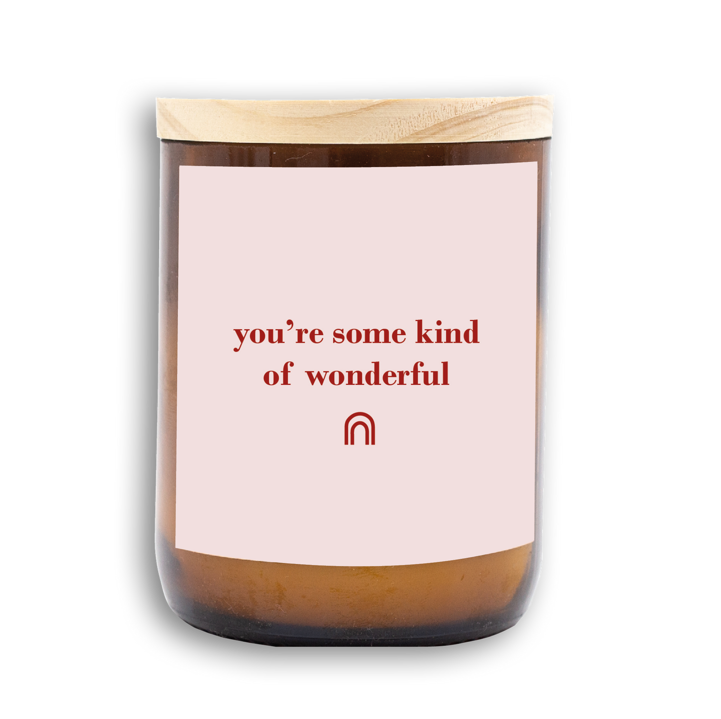 The Commonfolk scented candle with a pink label that reads 'you're some kind of wonderful' in red text, featuring a rainbow symbol, with a wooden lid.