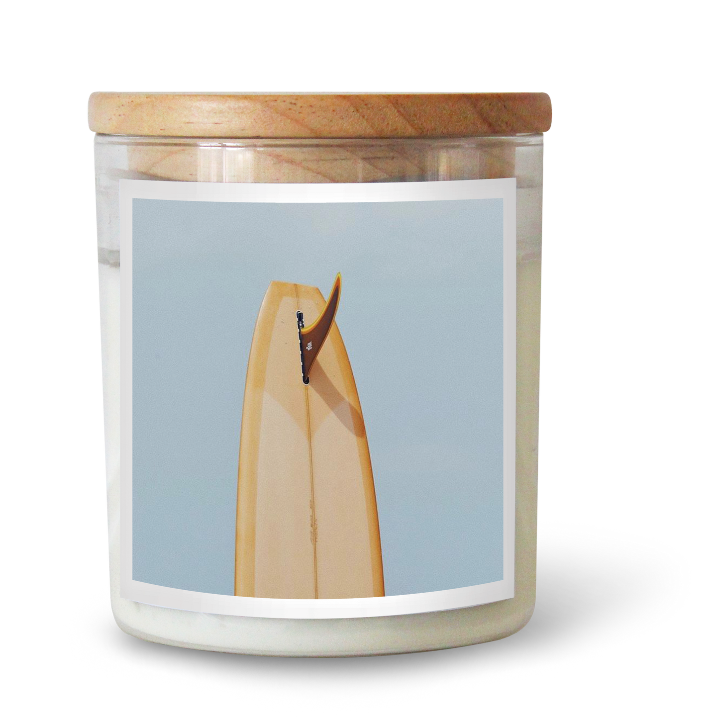 The Commonfolk scented candle comes in a white soy wax container, with a wooden lid and a label featuring a minimalist illustration of a surfboard.