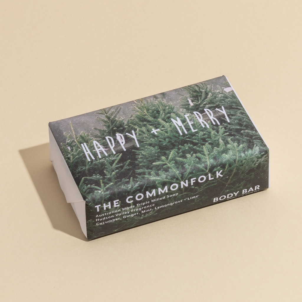 The Commonfolk 200g body bar soap labeled 'Happy + Merry' features a green foliage design, indicating that it is a body bar.