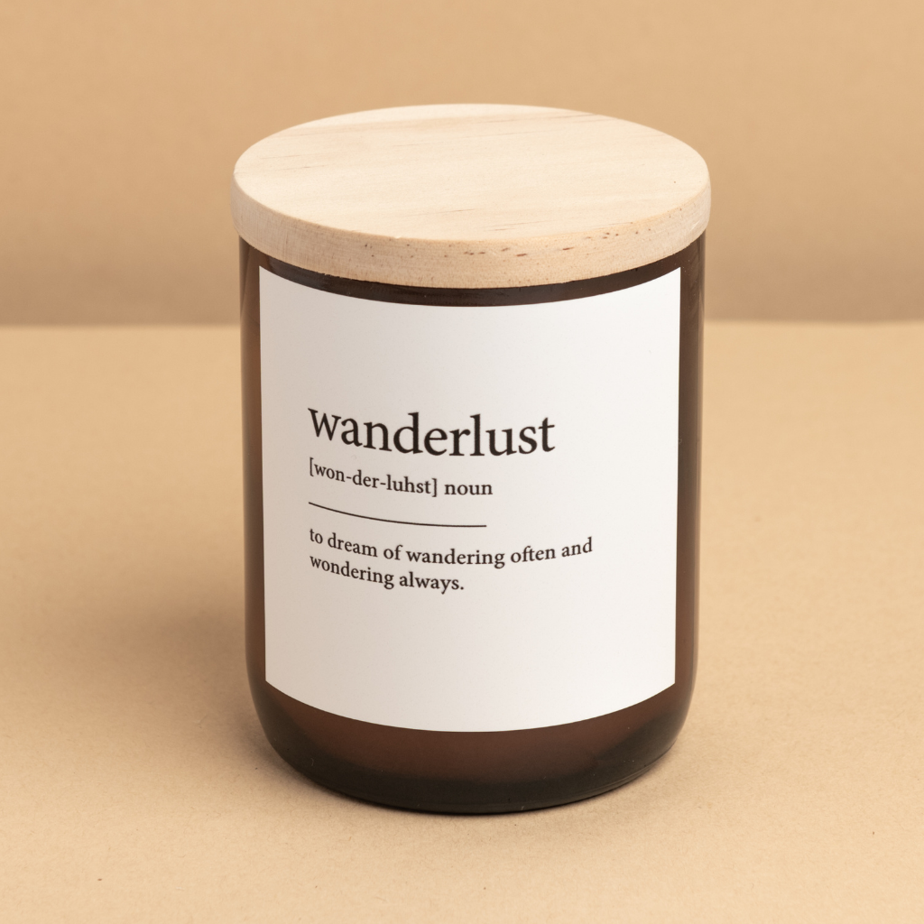 The Commonfolk scented candle, with a label that defines 'wanderlust' as a noun, is placed on a neutral background.