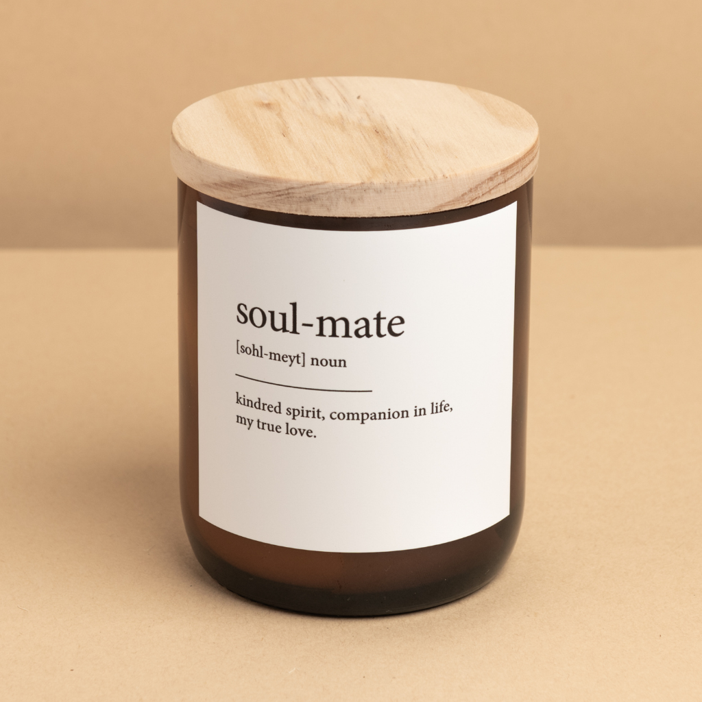 The Commonfolk scented candle with a wooden lid in an amber glass jar, labeled 'soul-mate' with a definition and quote.