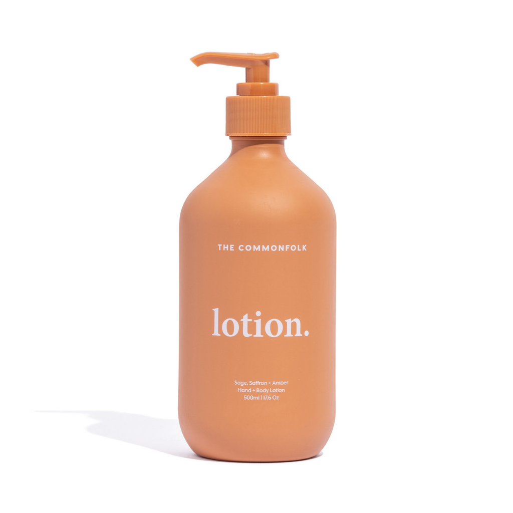 The Commonfolk matte finish 500ml bottle of body lotion with a pump dispenser, in a terracotta color, has white text that says 'lotion.'