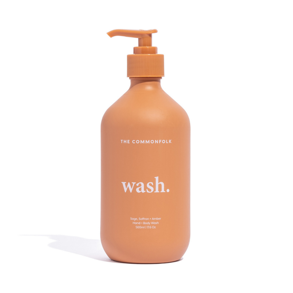 The Commonfolk matte finish 500ml bottle of hand and body wash with a pump dispenser, in a terracotta color, has the word 'wash' printed on it.