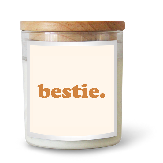 The Commonfolk scented white candle with a wooden lid, labeled 'bestie' in orange font on a clear label.
