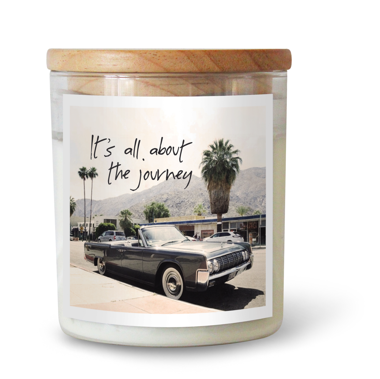 The Commonfolk scented candle features a label with a vintage car and palm trees, along with the text 'It's all about the journey.'