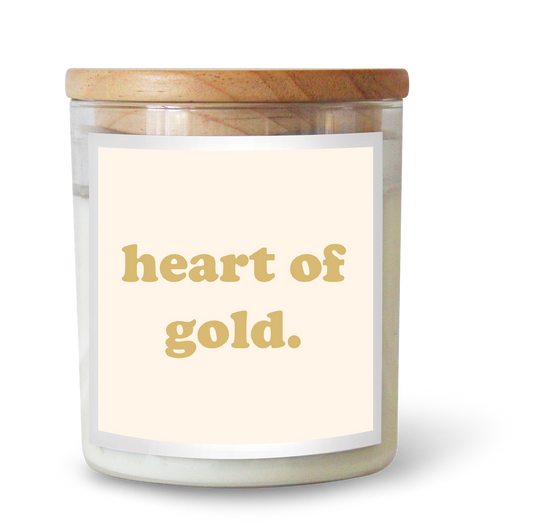 The Commonfolk scented white candle with a wooden lid, label reading 'heart of gold.'