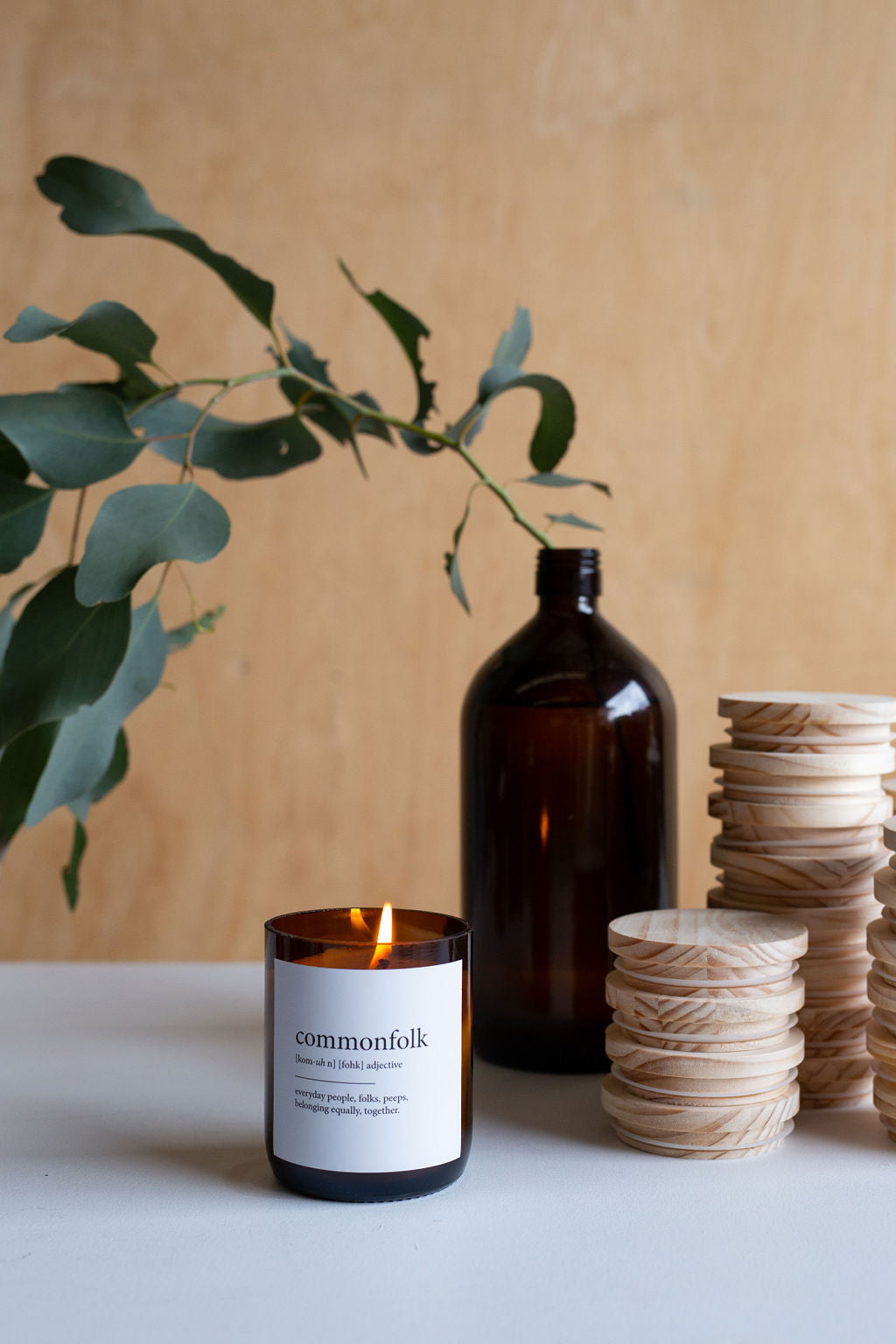 A candle on a table beside wooden lids creates a warm and inviting dining atmosphere.