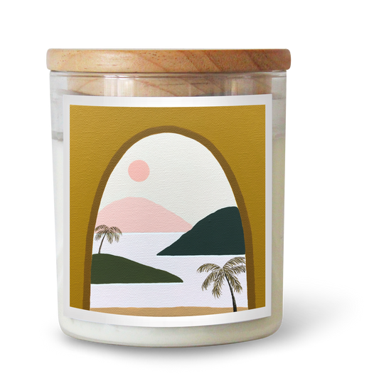 The Commonfolk scented candle comes in a clear jar with a wooden lid, featuring a printed label with a geometric design and a depiction of a sunset or sunrise scene with mountains and palm trees.