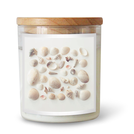 The Commonfolk scented candle comes in a glass jar with a wooden lid, decorated with embedded seashells on the label.