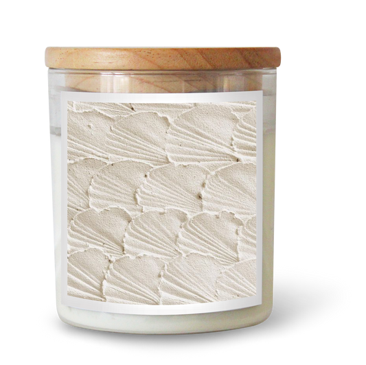 The Commonfolk scented candle features clear glass, white wax, a beige textured surface, and a wooden lid.