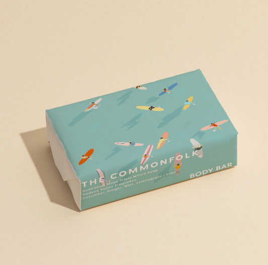 The Commonfolk 200g body bar soap with a blue wrapper featuring illustrations of surfers.