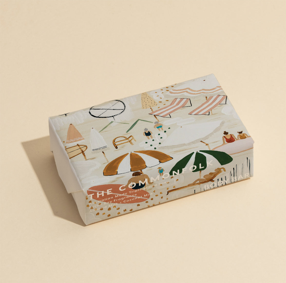 The Commonfolk 200g body bar soap features a decorative pattern with various elements, such as an umbrella and leaves, in a beige color scheme.