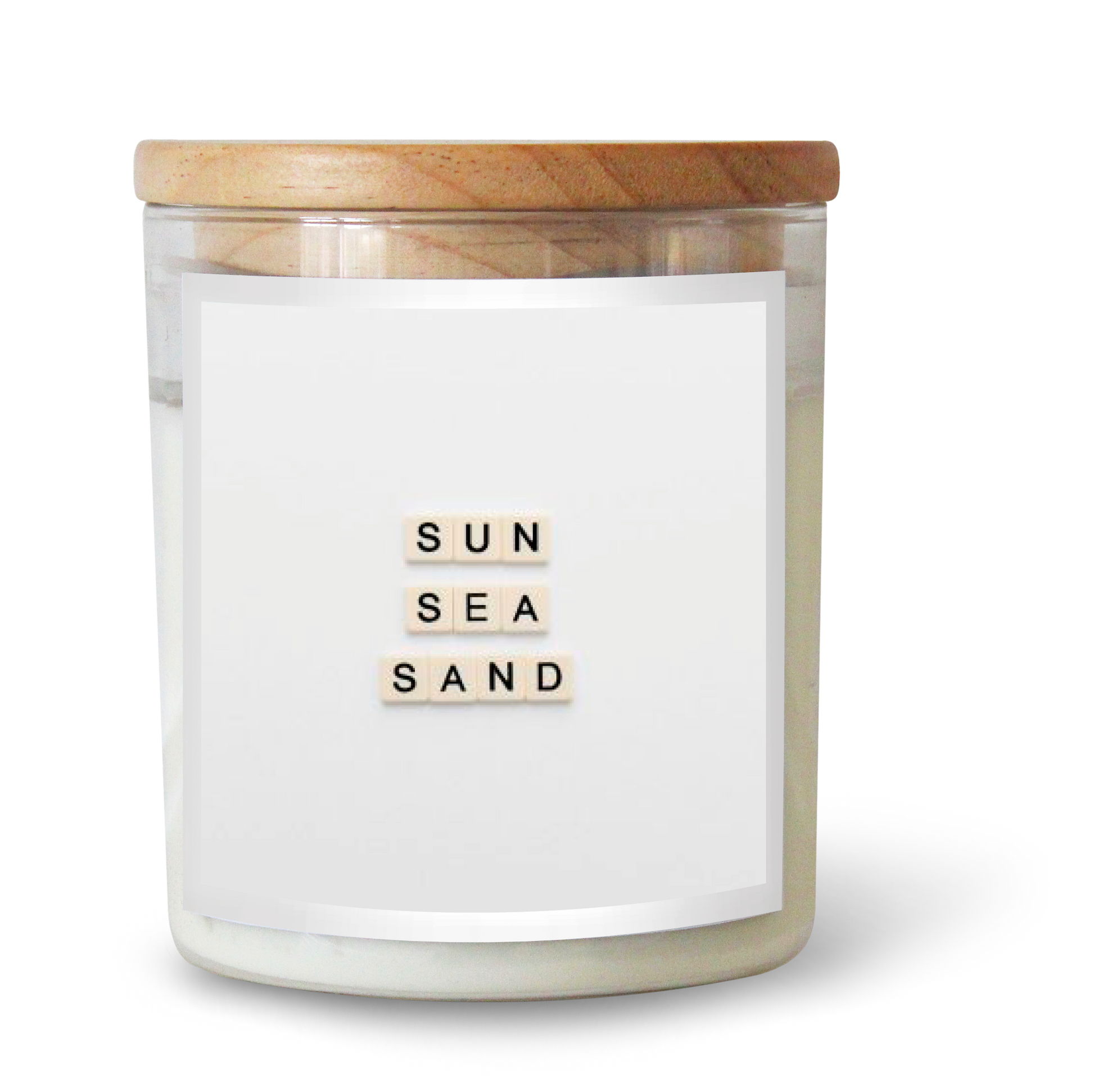 The Commonfolk scented white candle with the text 'SUN SEA SAND' on the label is contained in a clear glass jar with a wooden lid.