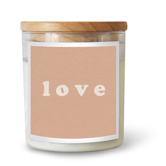 The Commonfolk scented white candle with a wooden lid and a label that has the word 'love' written on it in a simple font.