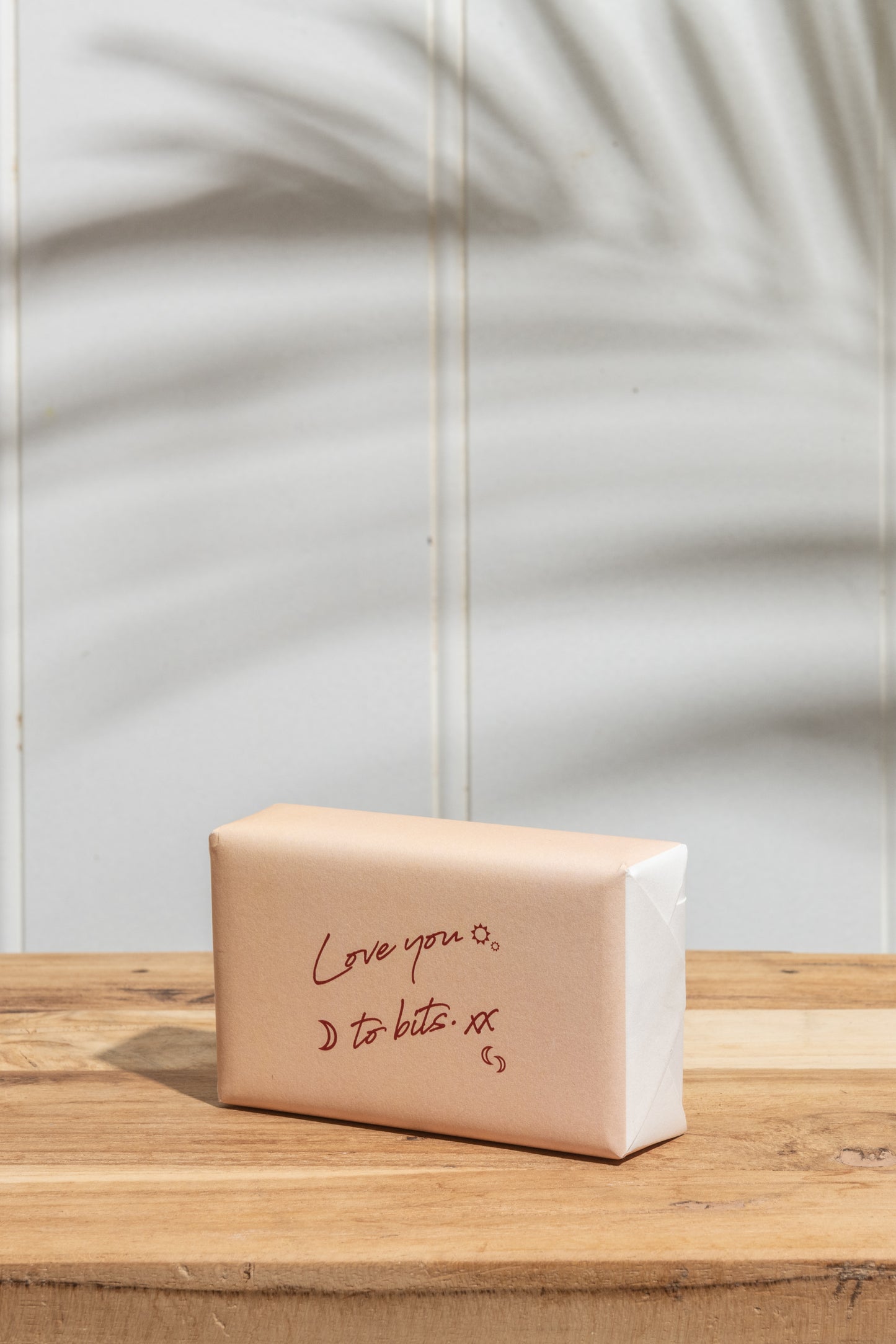 A bar of soap placed on a rustic wooden table, showcasing its simple design and natural surroundings.