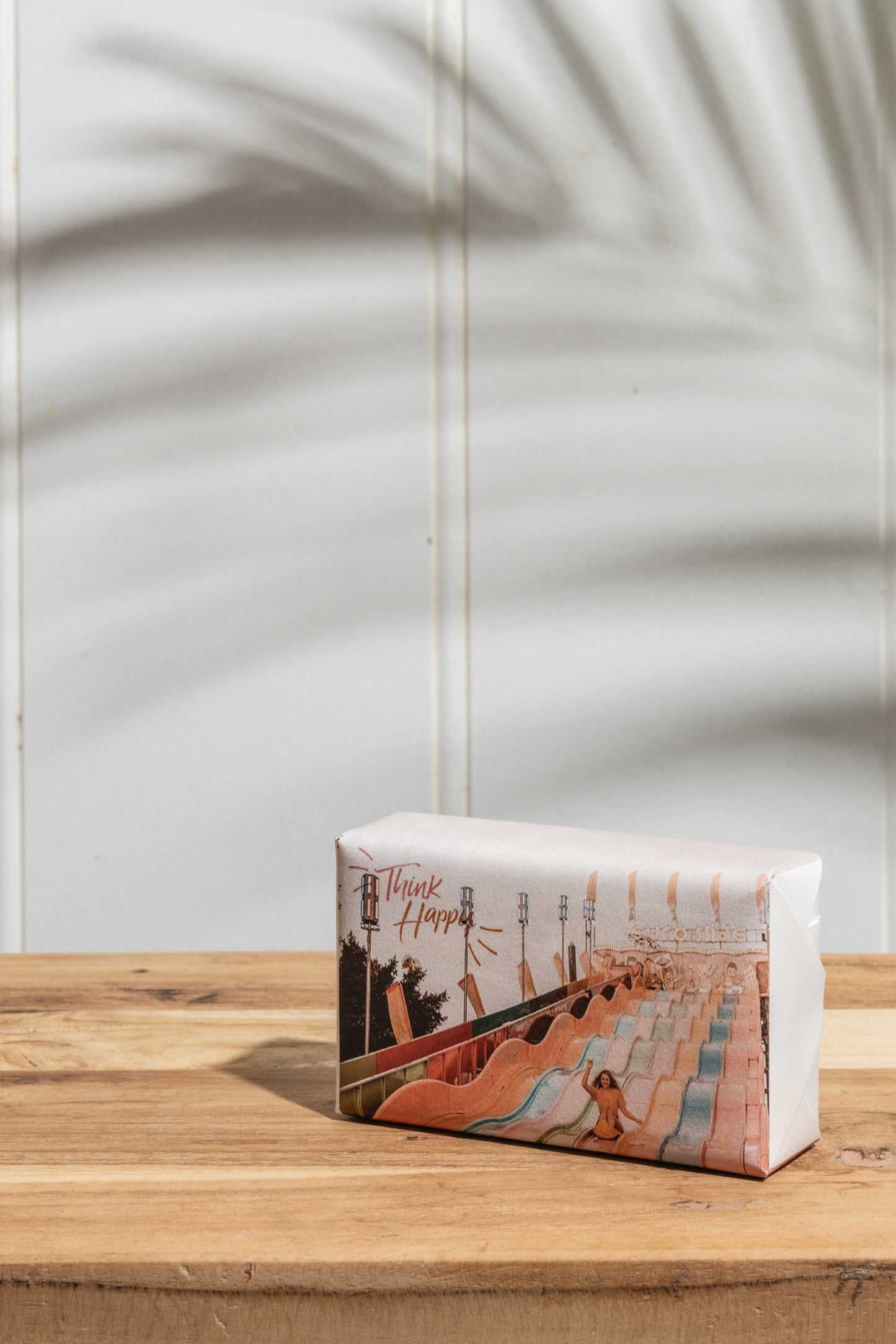 A bar of soap placed on a rustic wooden table, showcasing its packaging and texture.
