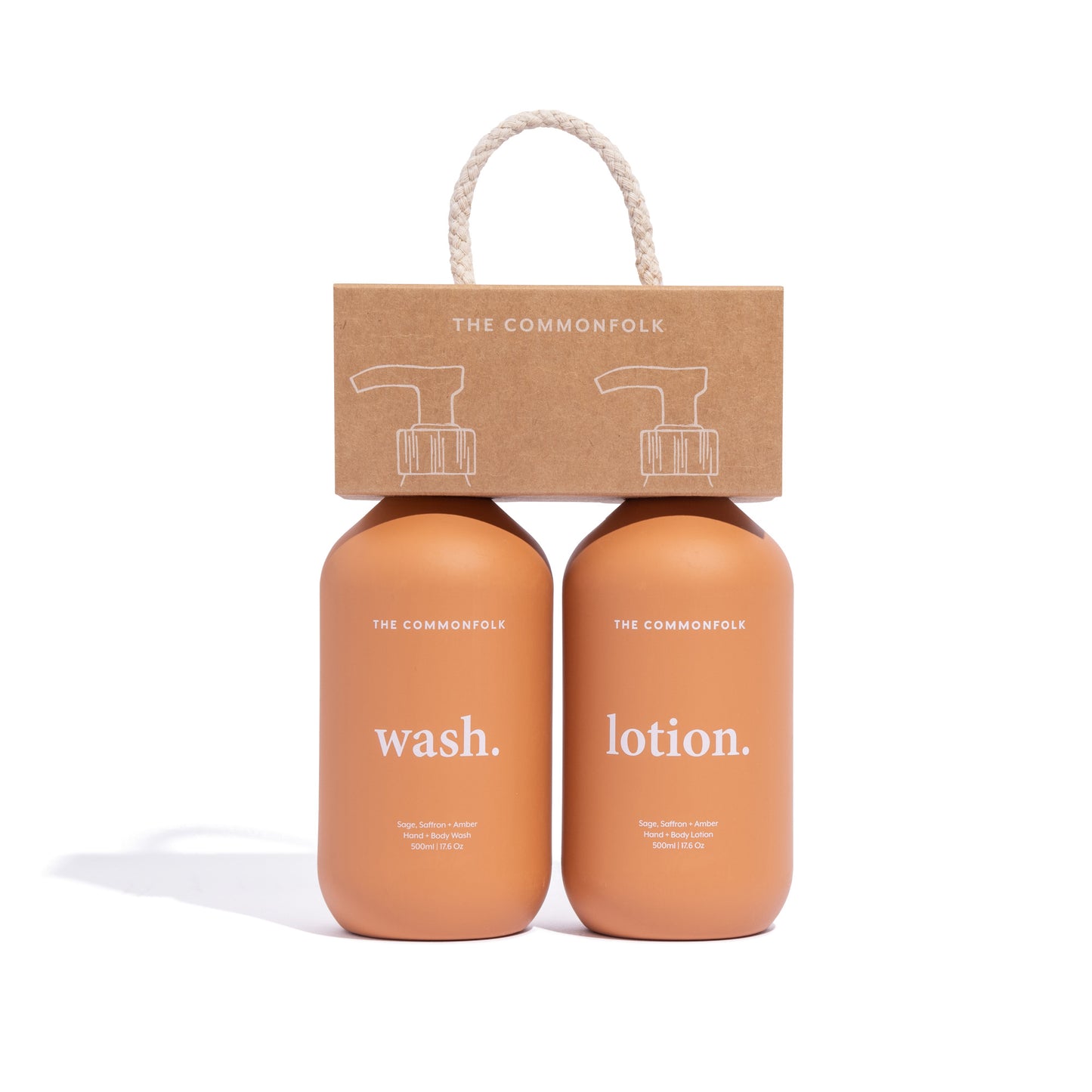 The Commonfolk two matte terracotta 500ml bottles, one labeled 'wash' and the other 'lotion', with a recycled Kraft carry caddy on top featuring a paper handle and a logo.