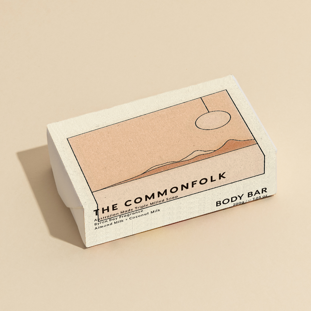 The Commonfolk 200g body bar soap features a minimalist design with a beige and brown color scheme and a mountain-like graphic.