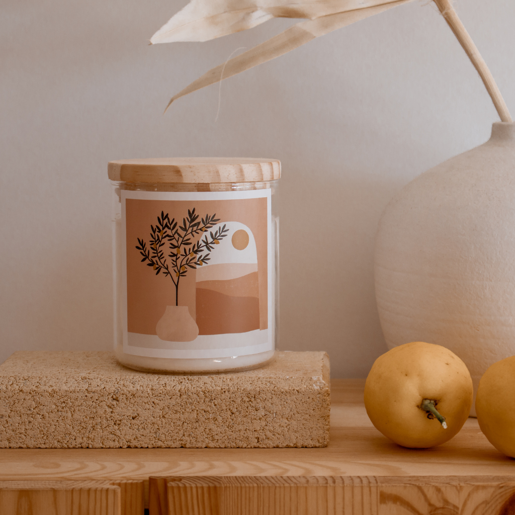 A candle on a wooden block beside fresh lemons, creating a warm and inviting atmosphere.
