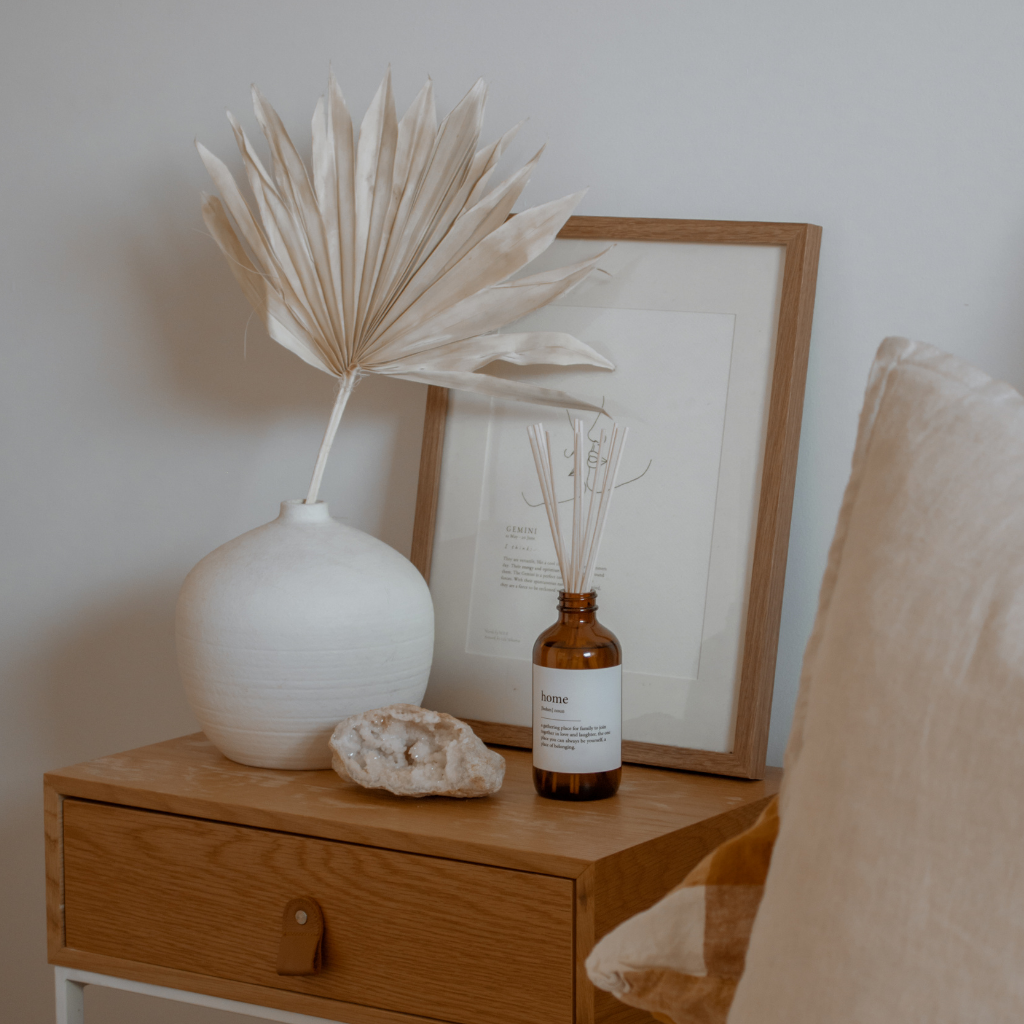 A nightstand featuring a small plant and a room diffuser on top.