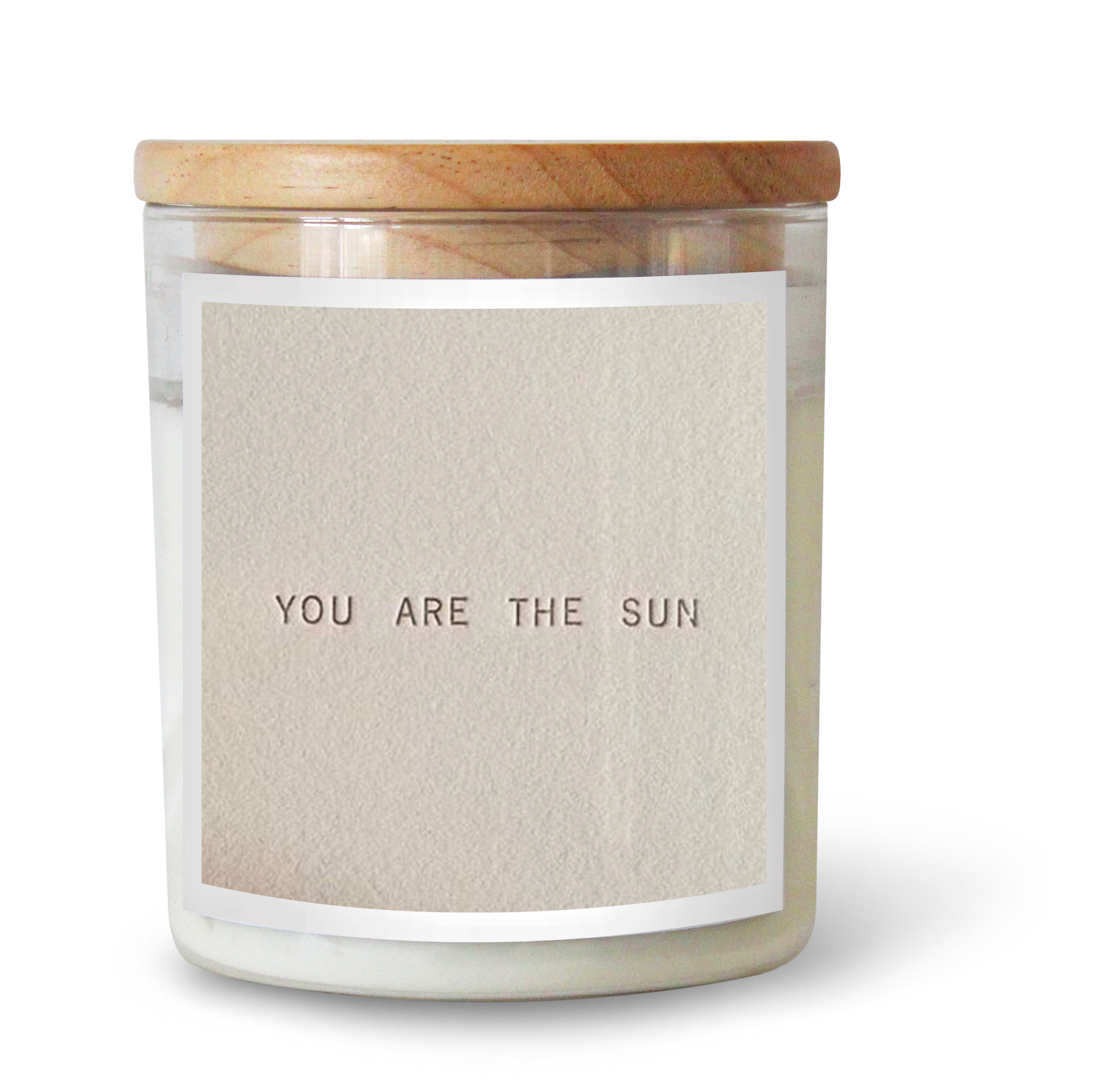 The Commonfolk scented white candle with a label that reads 'YOU ARE THE SUN', contained in a clear glass jar with a wooden lid.