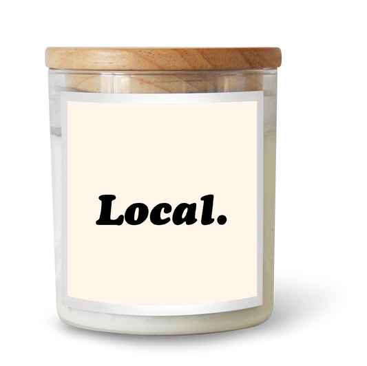 The Commonfolk scented candle has a white label that reads 'Local.' on a wooden lid.