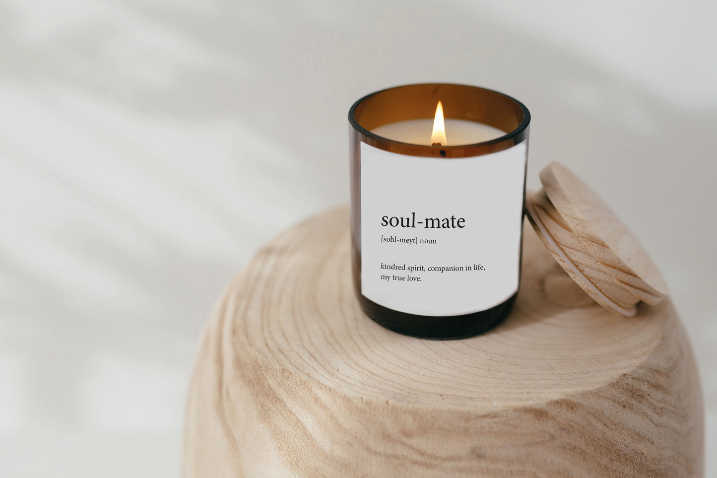 A beautifully crafted candle with the word "soul-mate" on it, designed to enhance a romantic setting with its warm light.