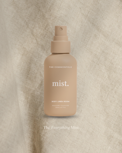 Beige spray bottle labeled 'mist' on a textured beige background