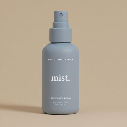 Denim color spray bottle labeled 'mist' by The Commonfolk on a beige background