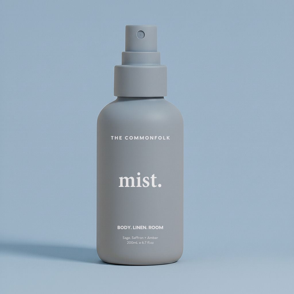 Denim color spray bottle labeled 'The Commonfolk' on a light blue background